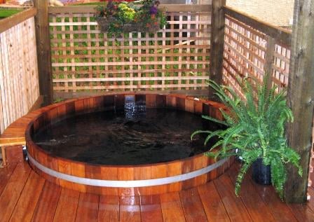Cedar hot tub on a backyard deck, one option for where to put a hot tub